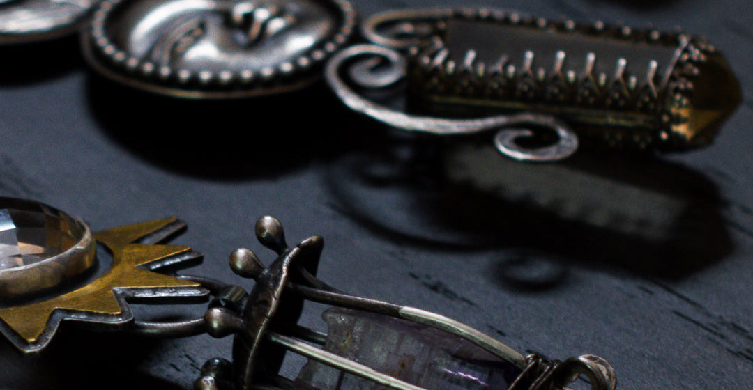 Close up of a ritual pendant.  Sterling silver moonface and raw citrine crystal point and forged wire spirals.
