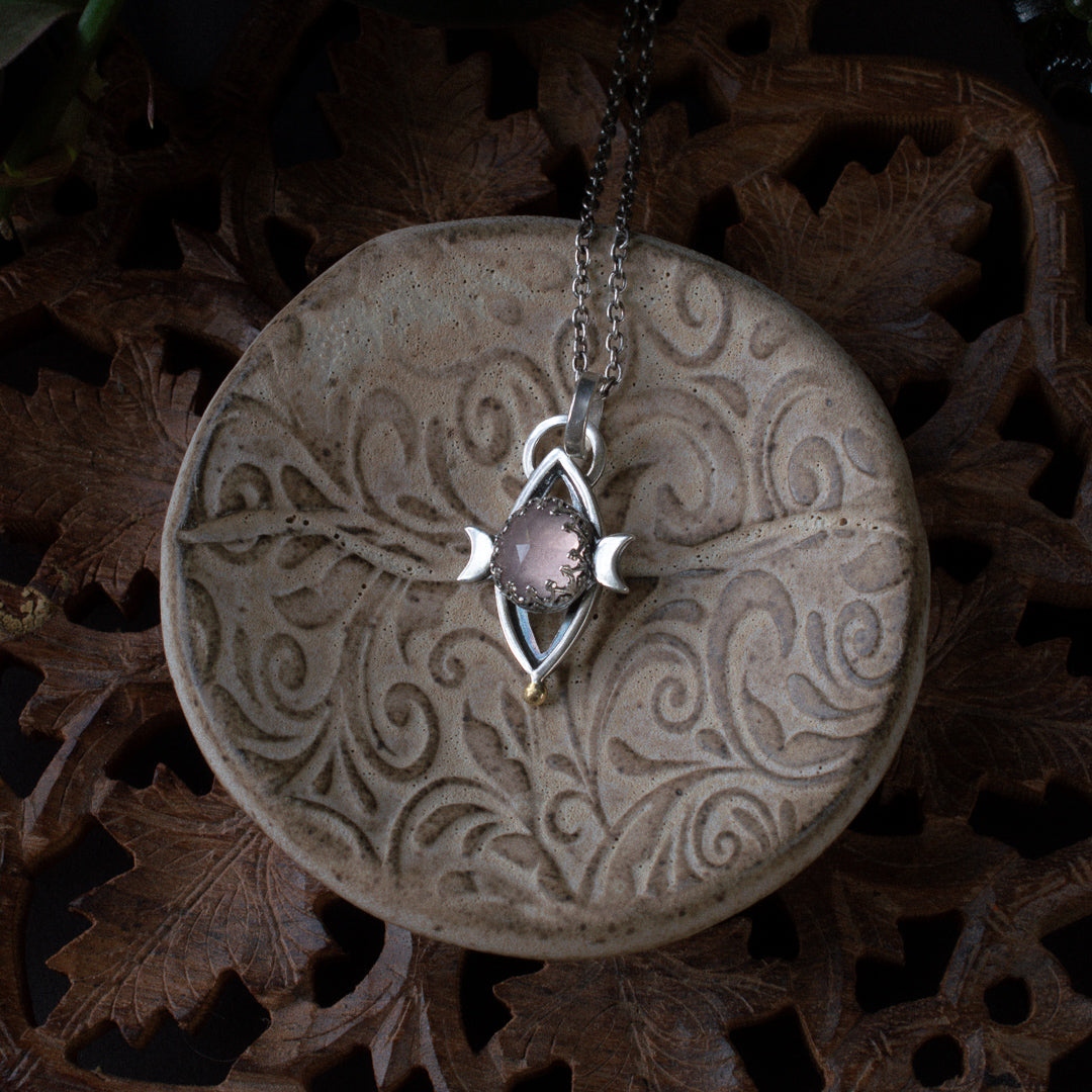 Layered sterling silver pendant with arose quartz triple goddess symbol over sacred geometry.