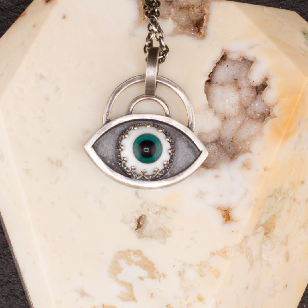 Close up of simple handmade sterling silver eye talisman.