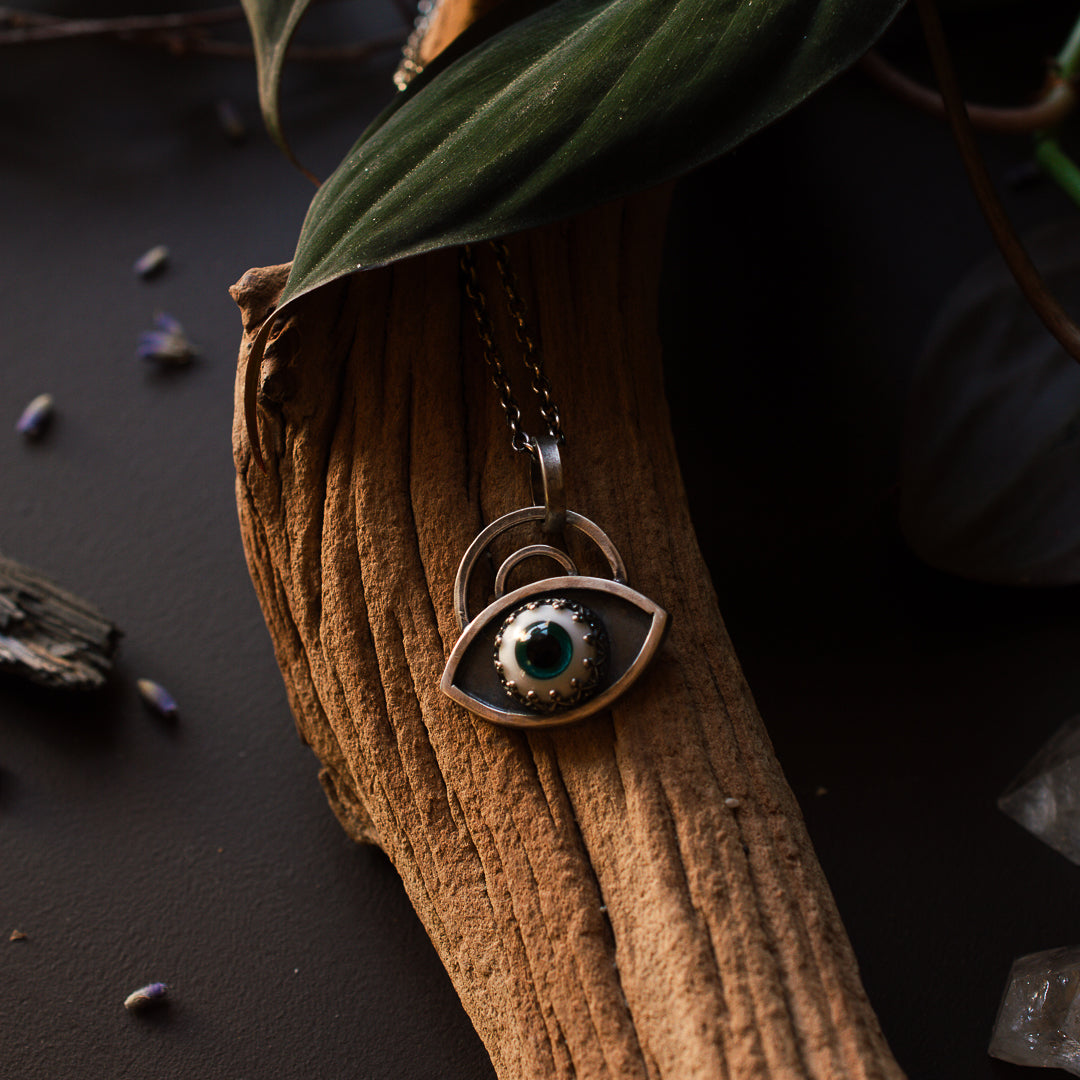 Teal evil eye pendant in sterling silver.