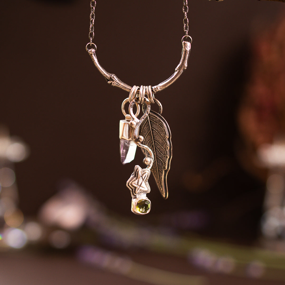 A nature inspired charm collection with green tourmaline, raw Vera Cruz amethyst point and a cast leaf. They are all on a sterling silver cast branch necklace.