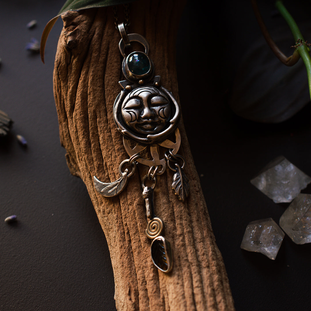 Sterling silver sleeping moon face talisman with tourmaline, nature elements and aqua kyanite.