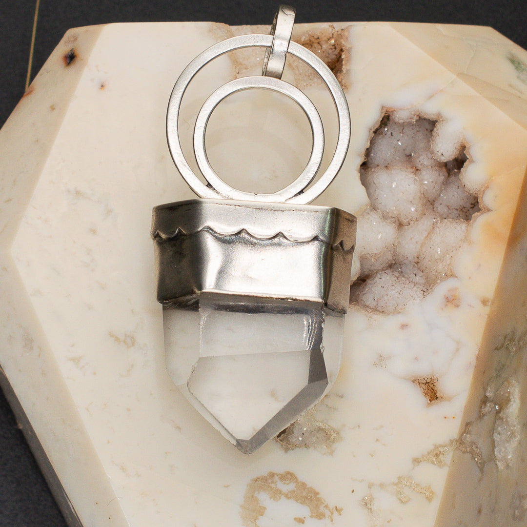 Simple clear quartz point pendant in sterling silver.
