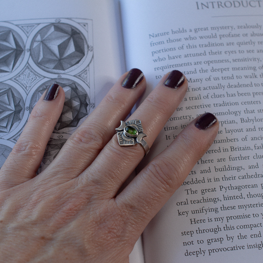 Crescent moon and green tourmaline sterling silver ring shown on a hand.