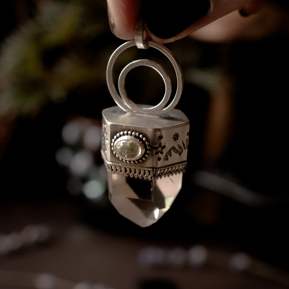 Chunky polished clear quartz talisman pendant with pale mint tourmaline accent stone.