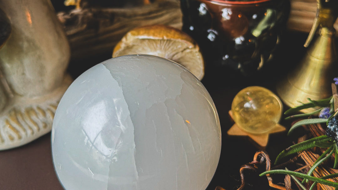 Selenite and honey calcite crystal balls with a triple goddess bell.