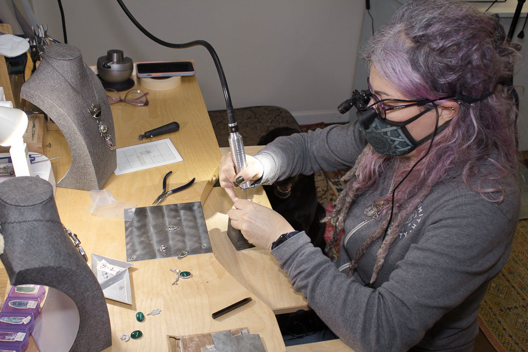 Metalsmith at Earth Energy Alchemist working at her jewelr's bench.