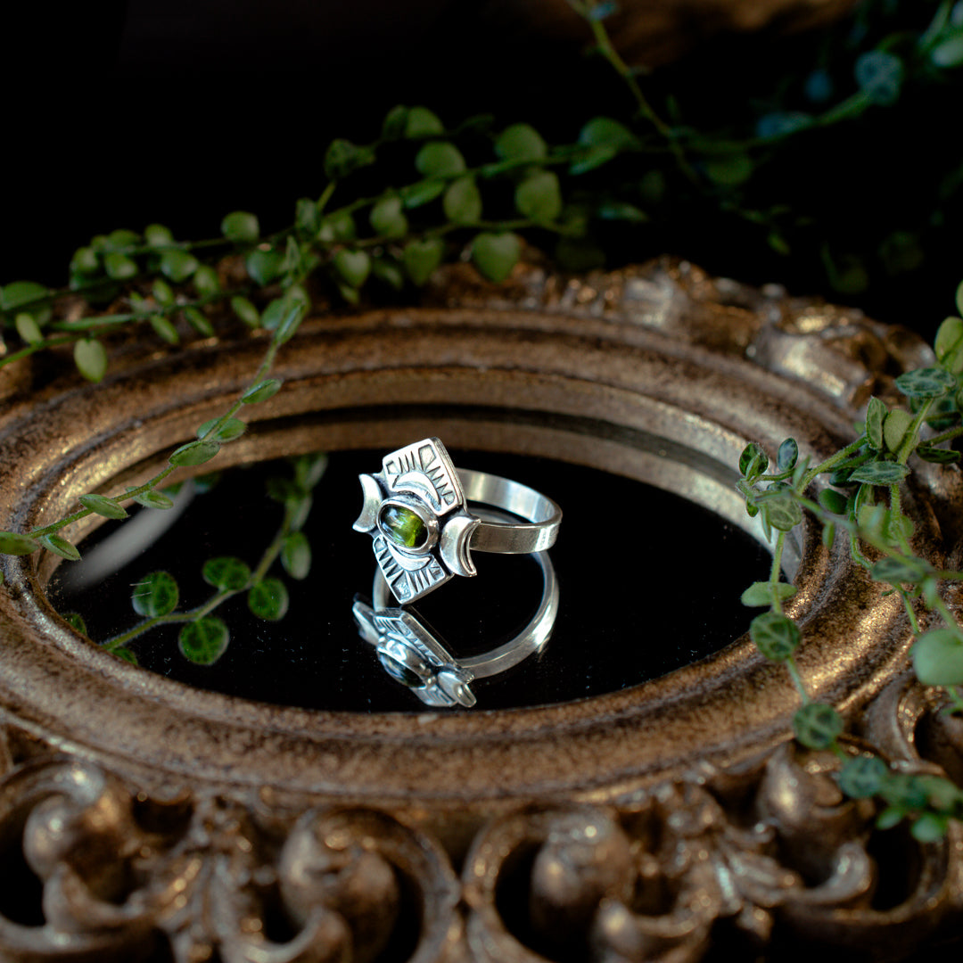 Bright green tourmaline ring with crescent moons and stamped details.