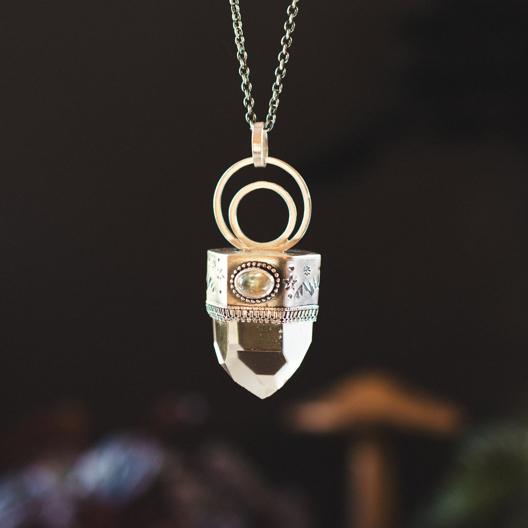 Clear quartz point with tourmaline set in sterling silver.